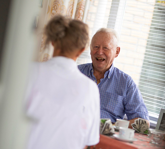 Omsorg Sjælland mand drikker kaffe med hjælper